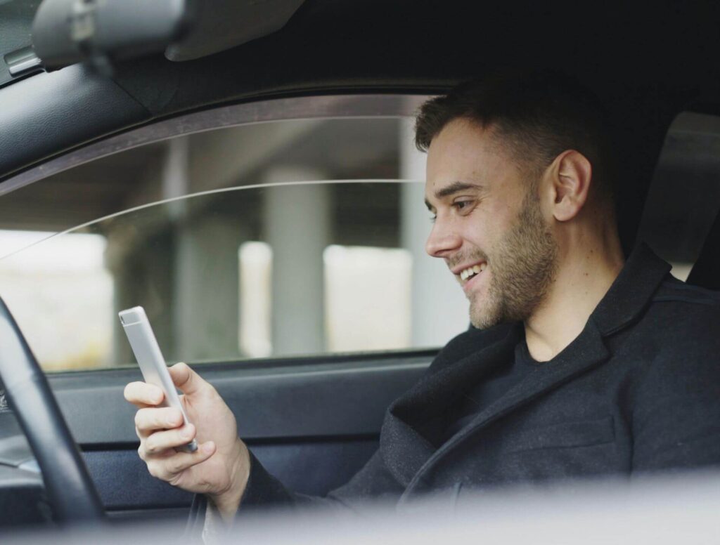 Man in car looking at his phone