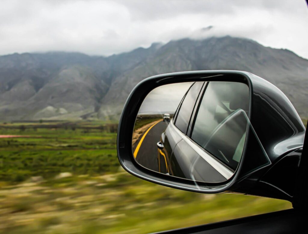 Car mirror with mountains in the background