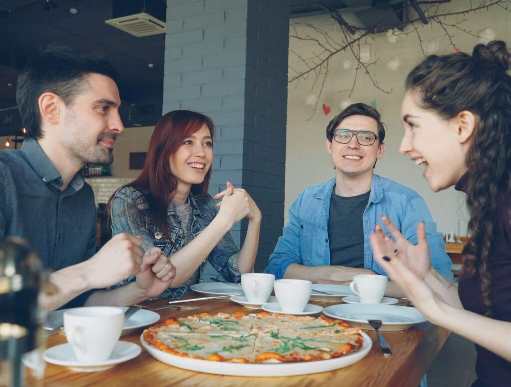 Group of four eating pizza and talking