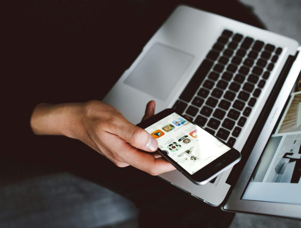 person using cell phone and laptop