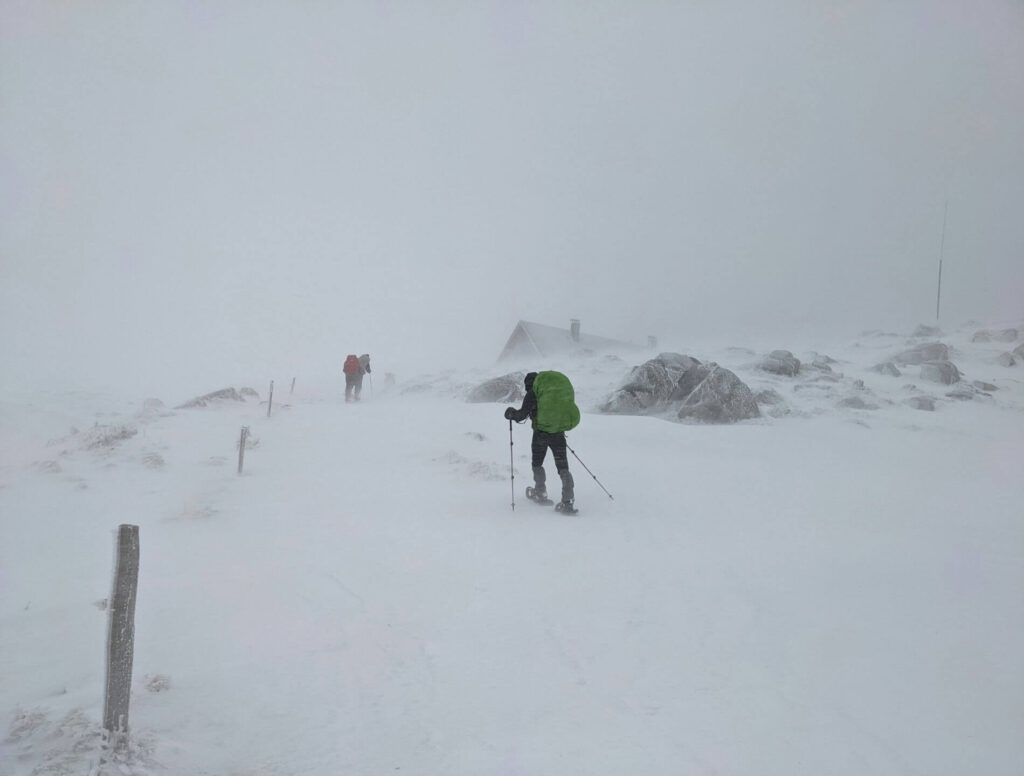 Two men climbing a mountain in heavy snow
