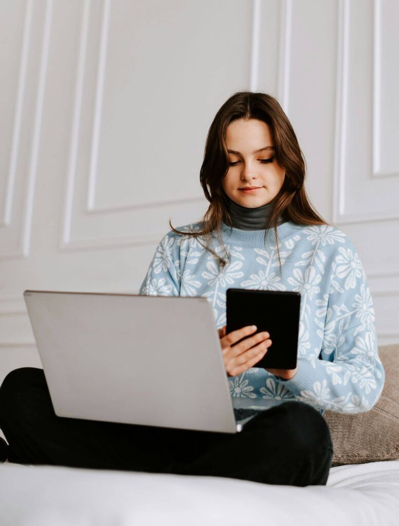 girl on her bed using a laptop