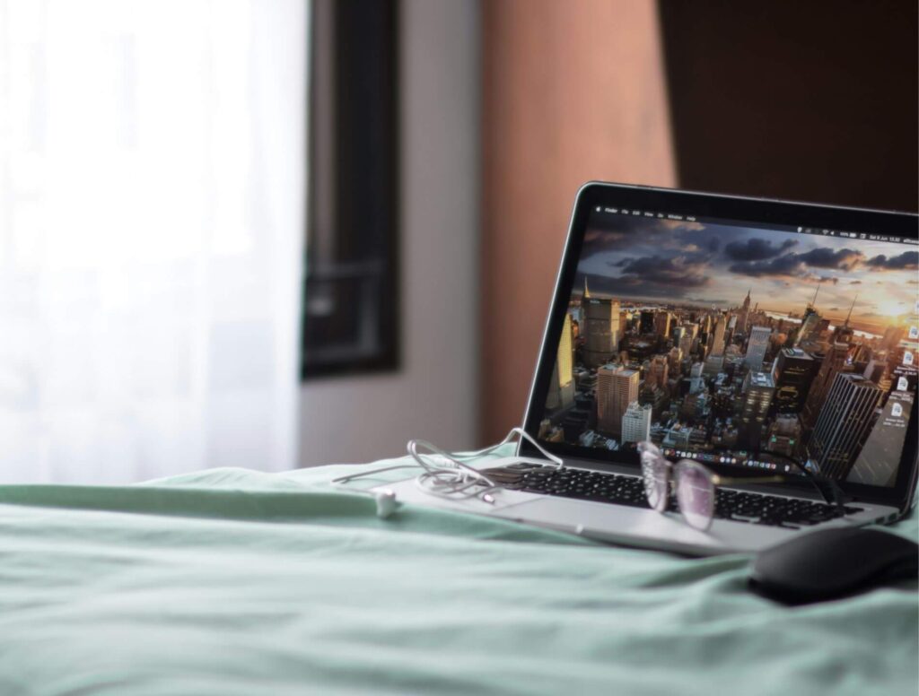 open laptop on top of a bed
