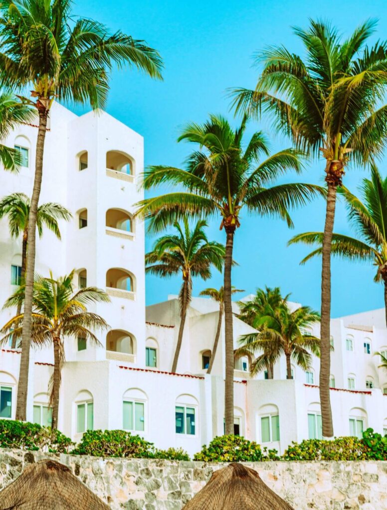 White apartment building surrounded by palm trees