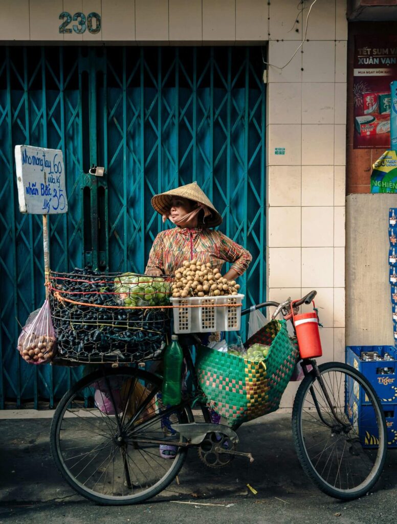 Asian woman selling food from her bicycle