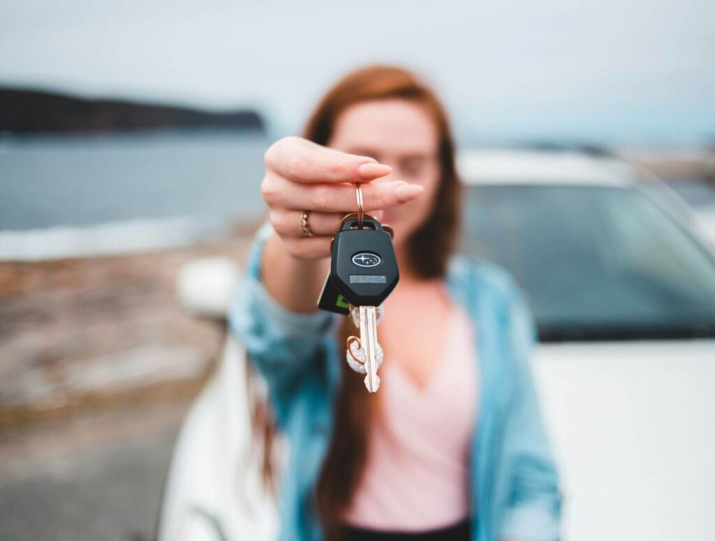 Woman handing over keys to a rental car