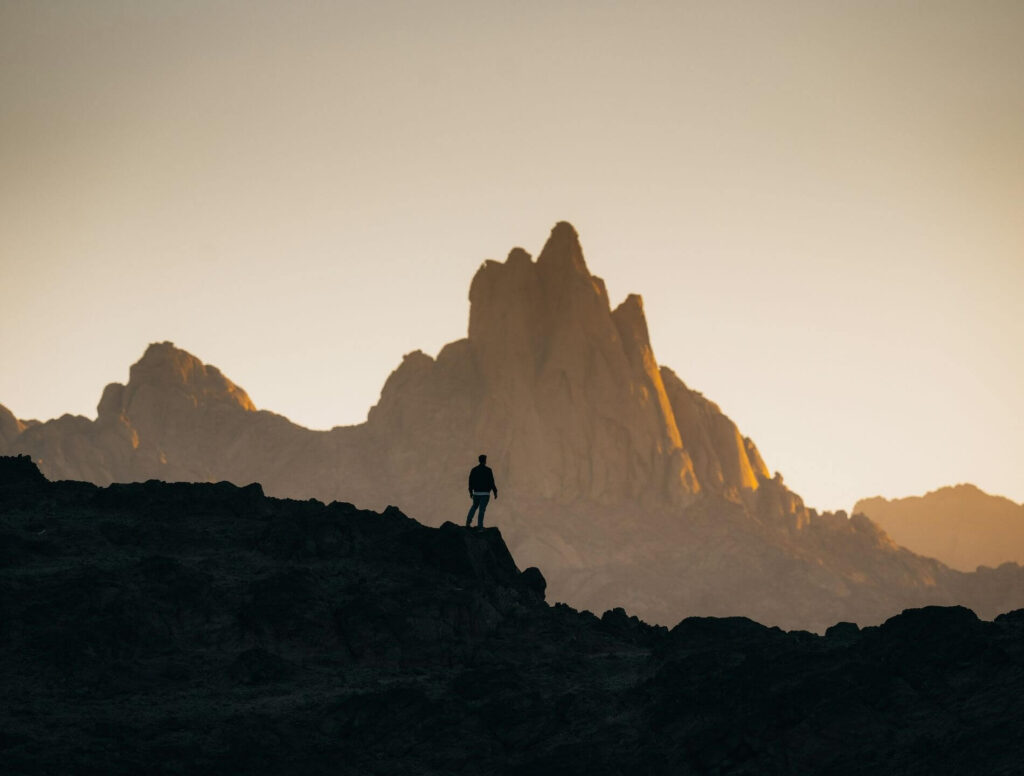 person's silhouette with mountains in the background