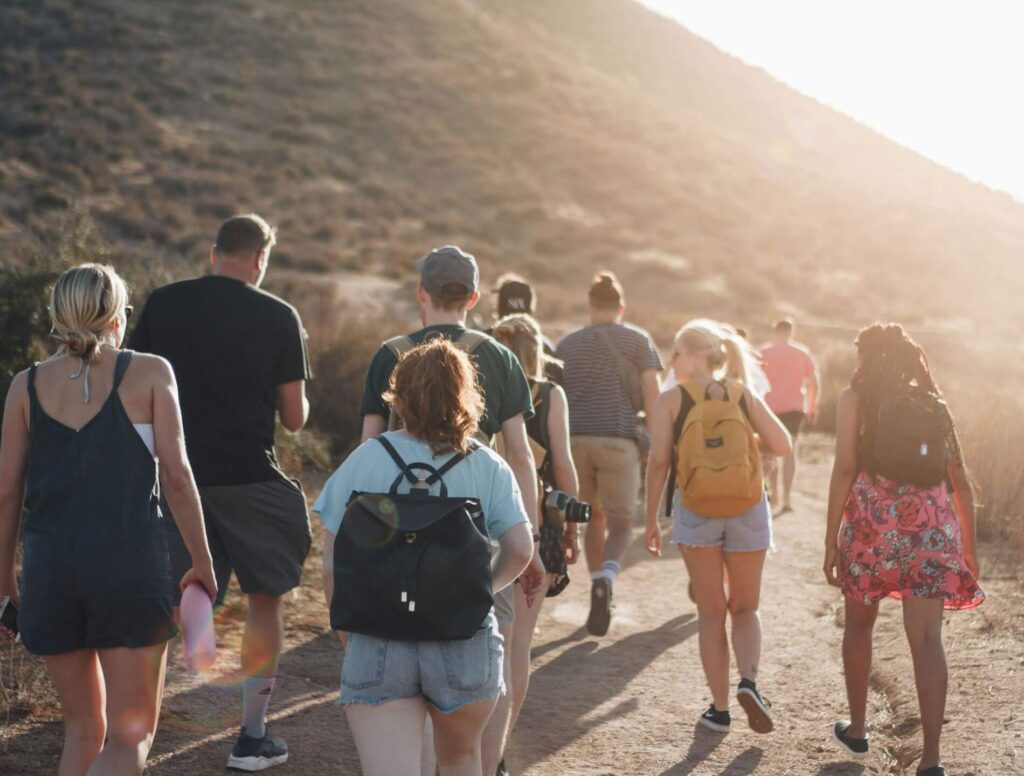 Group of young adults walking up a mountain trail